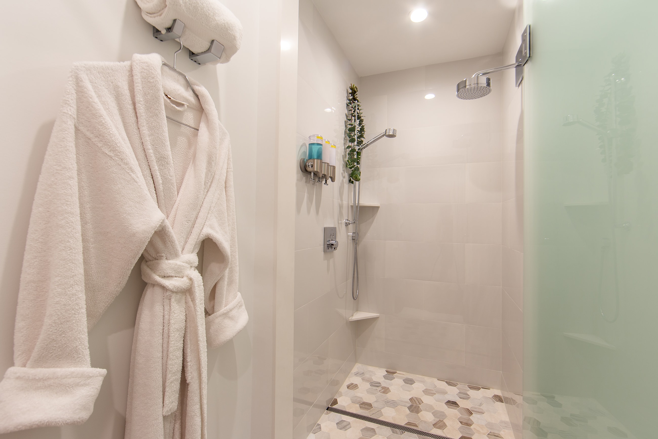 Modern shower with towel and bathrobe hanging.