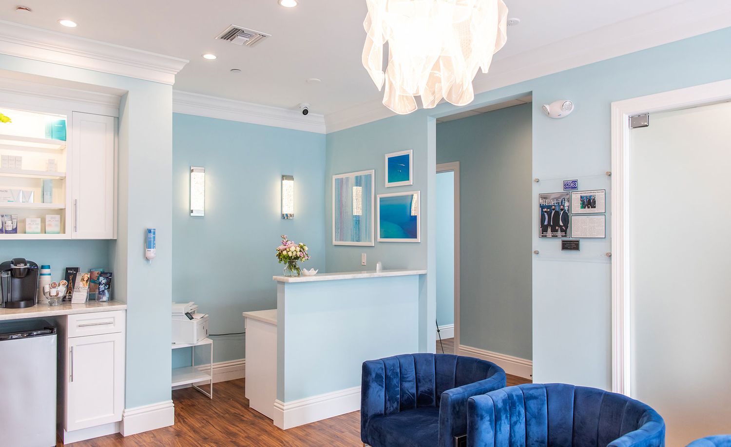 Modern medical office with blue decor and seating.