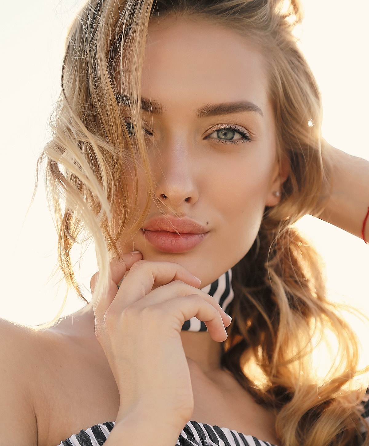 Woman's portrait with greenery and soft lighting.
