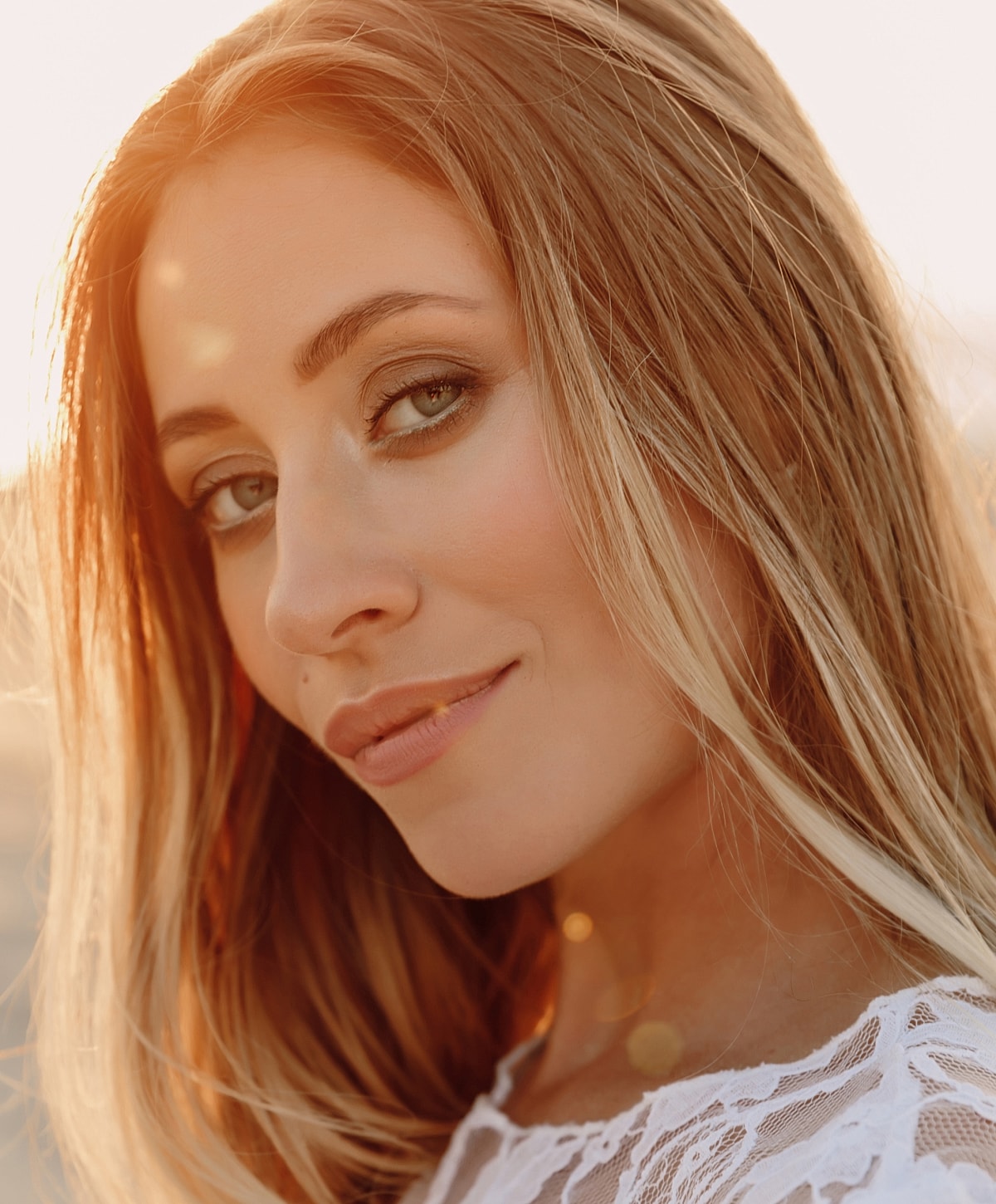 Woman with long hair against sunset background.