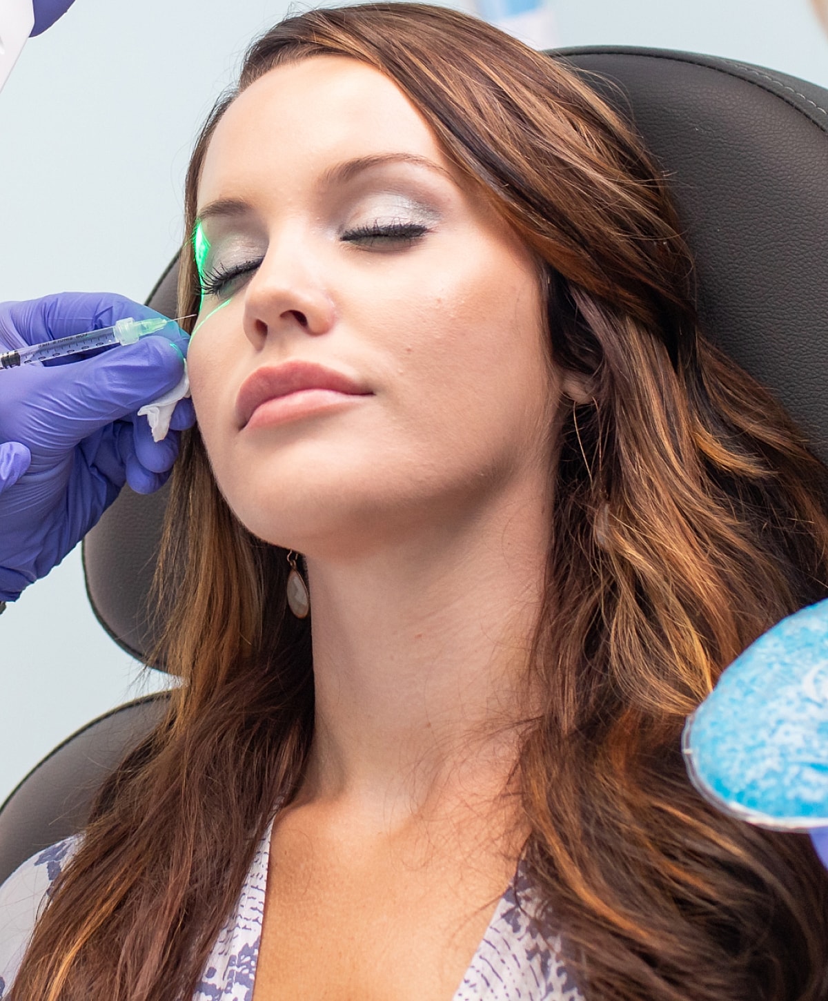 Portrait of woman with sleek hair and earrings.