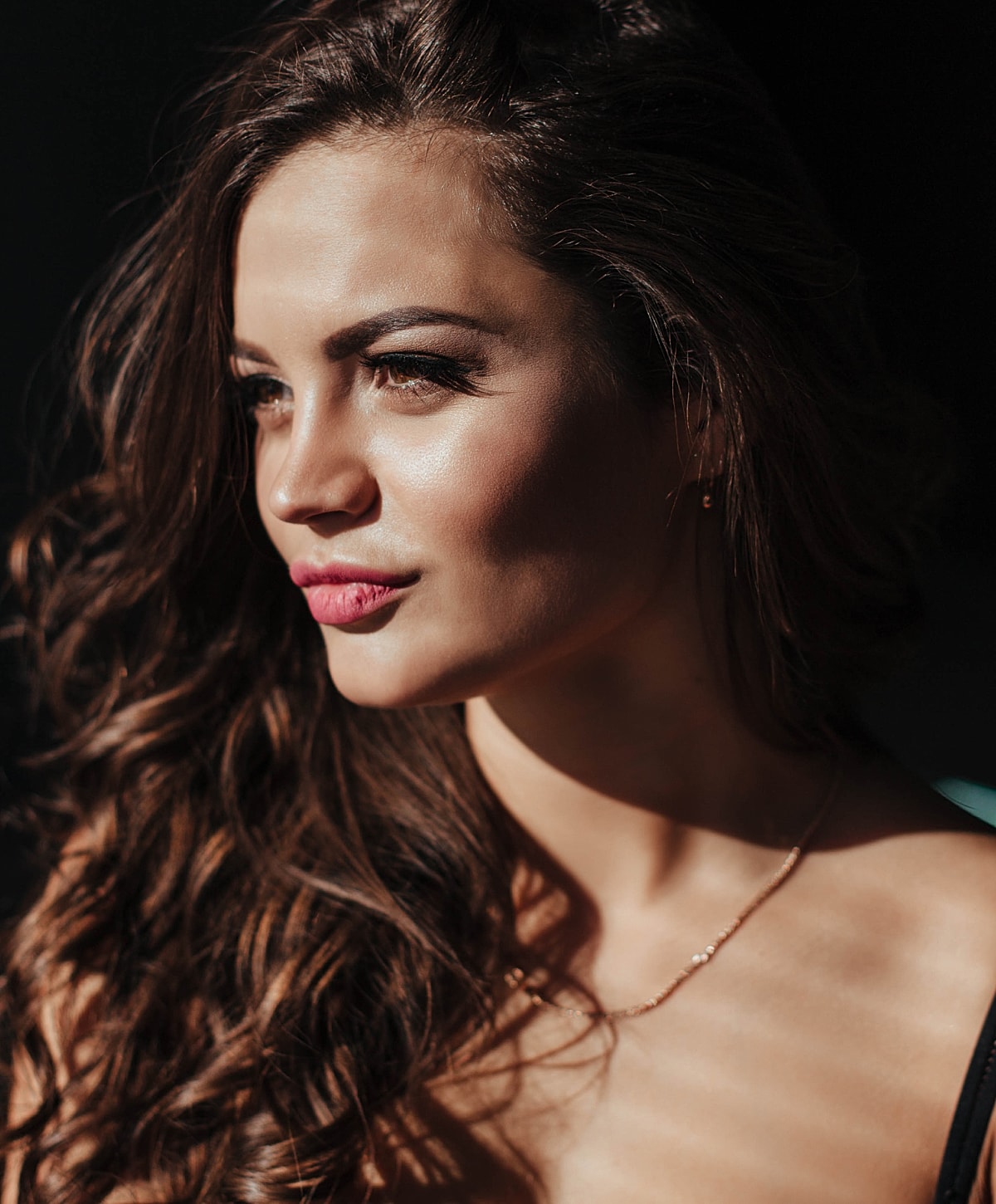 Close-up of woman with curly hair and makeup.