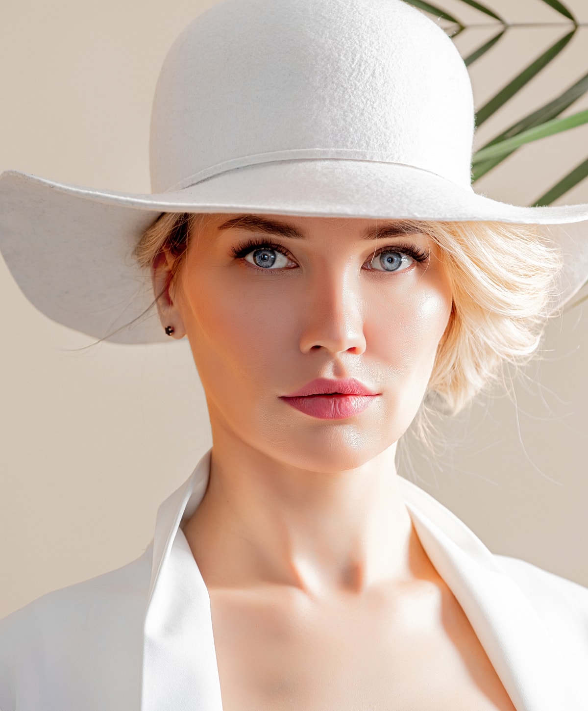 Woman in white hat and stylish outfit.
