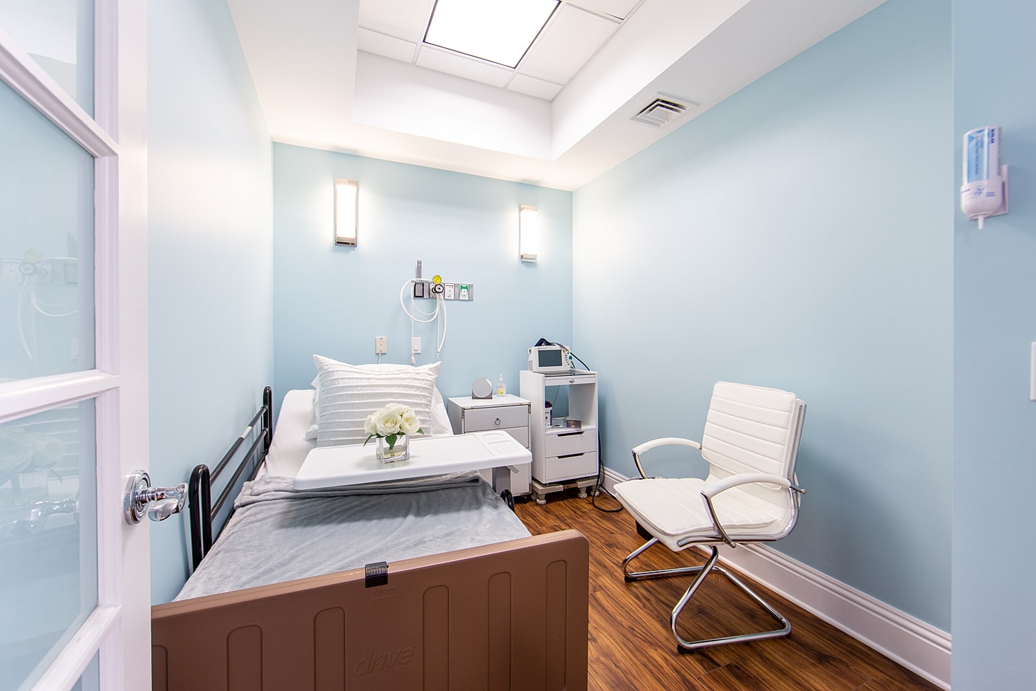 Medical room with bed and chair setup.